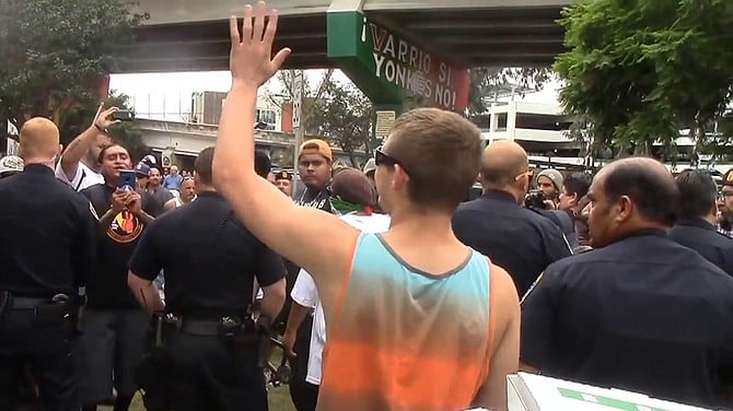 Surrounded by police protection one patriot picnic-goer waves to the crowd pressing in against him.