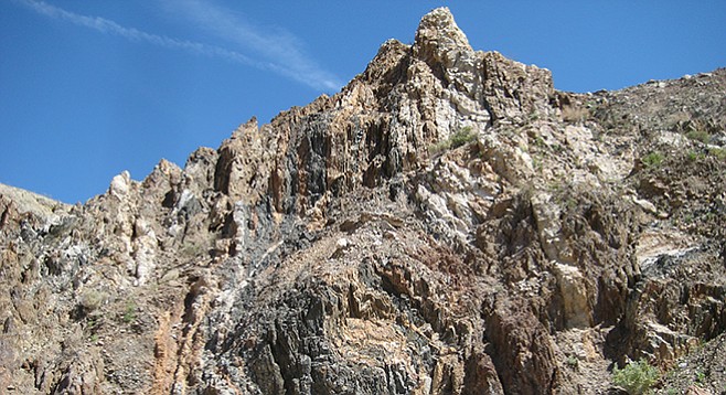 Alverson andesite shows up as a dark, non-linear vein piercing through the northern hillside