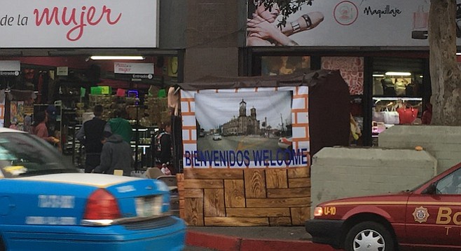 The straight lines of the framed tarps make this vendor's stand blend with the façade and sidewalk-scape.