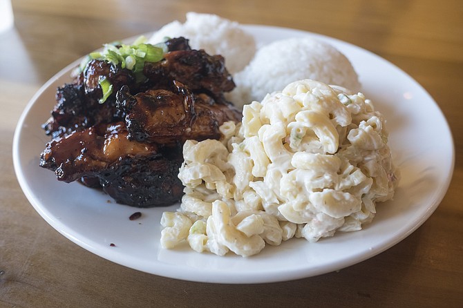 A Hawaiian plate lunch, with pile of charred chicken, plus scoops of rice and macaroni salad.