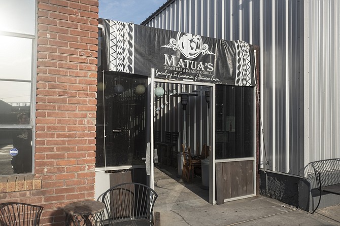 A doorway into an alley of brick and corrugated metal