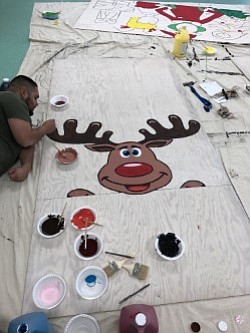 Gilbert of Golden Hill Recreation Center paints a ring toss game for Winter Play Day