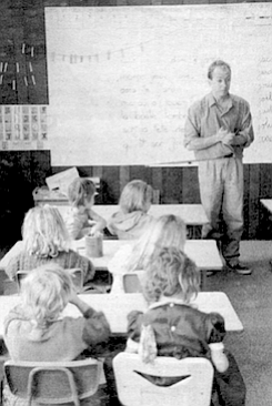 Jacques Moiroud stands in front of his class of kindergartners and first graders. In France the tradition is for men, not women, to teach the younger grades.
