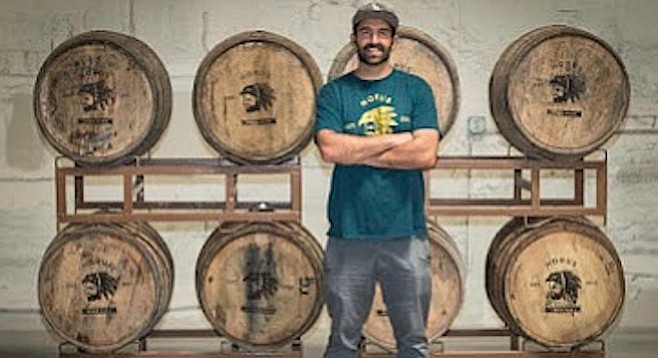 Brewer Kyle Harrop stands before a rack of barrels at his brewery, Horus Aged Ales