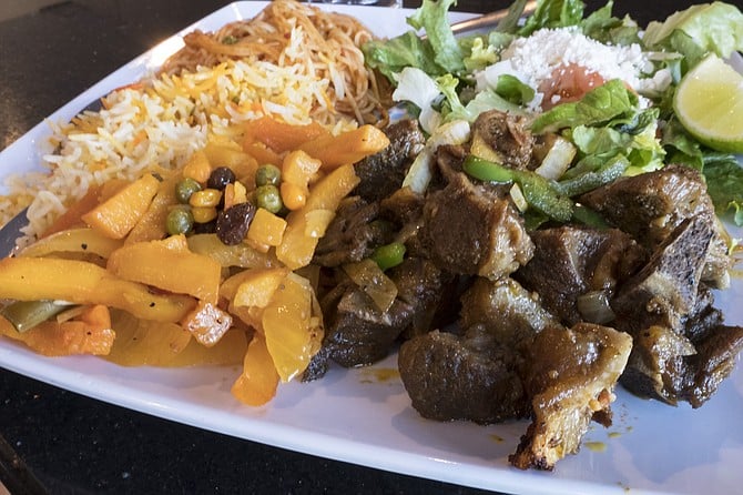 Somali dishes including goat and potatoes plus salad, rice, and pasta