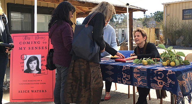 Alice Waters then (on the book cover) and now (at the table)