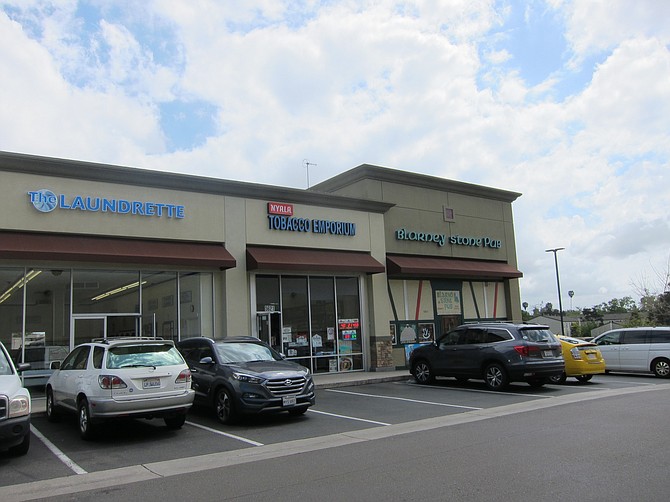 Directly adjacent to the proposed homeless housing are amenities like a laundromat, tobacco shop, and bar. 