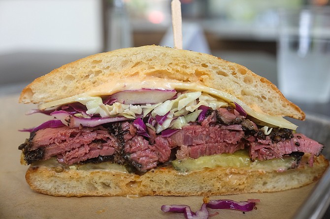 A Reuben-like sandwich with a house pastrami of hickory-smoked brisket, served on a ciabatta.