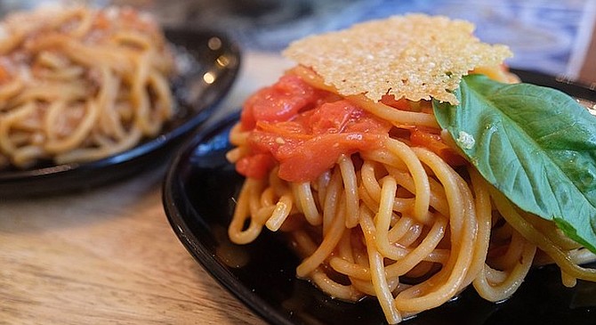 A pasta entree split into two mini entrees: scarpariello (front) and bolognese.