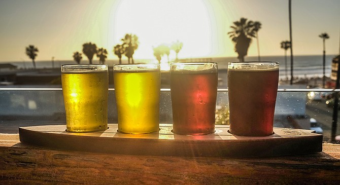 A flight of beers on the rooftop of OB Brewery, looking west as the sun goes down.