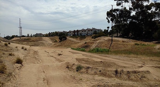 The proposed housing site, where local youth come to ride their bikes, abuts the Park Point Loma townhomes (background)