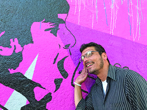 Carlos Quezada listens for a mural message