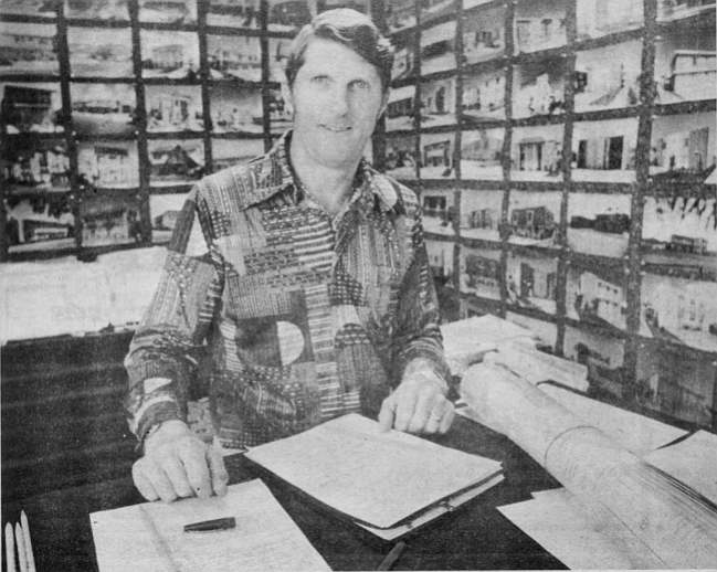 Huffman surrounded by photos of his projects

