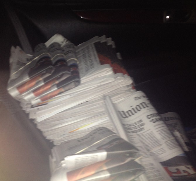 In the back of Bob's Lexus, I'm surrounded by newspapers that need folding.