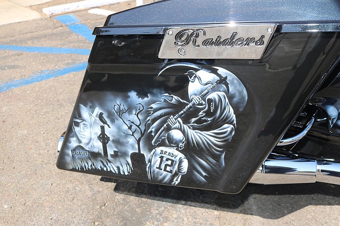 A female fan was posing on a motorcycle with an airbrush design of a Chargers’ gravesite headstone.