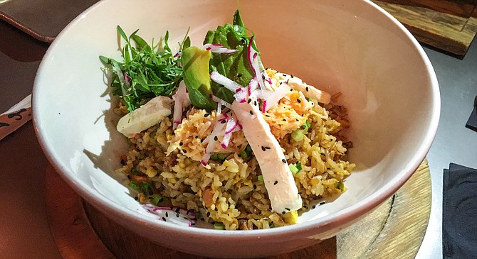 Sliced bits of cream cheese in a Mexican styled fried rice, along with spicy crab, avocado, micro cilantro