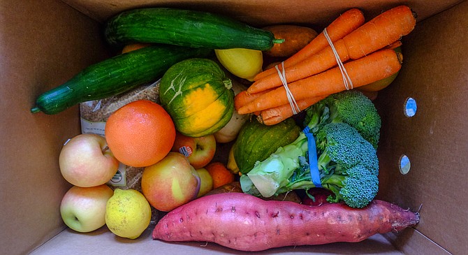 A speckled lemon, flat sided orange, scarred squash, and slightly misshapen carrot are part of a box home-delivered by Imperfect Produce.