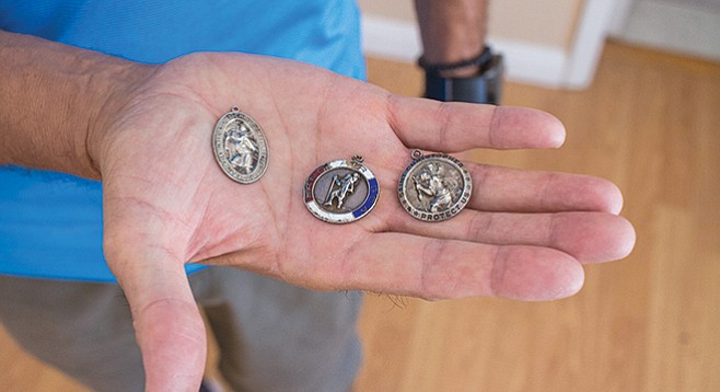 Donald Carr's St. Christopher Medal and more medals from Vietnam in Antonio Palma's hand. - Image by Matthew Suárez