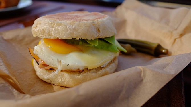 Ham and avocado egg sandwich in a Wayfarer English muffin, served alongside a cup of joe made with beans from Encinitas's Ironsmith Coffee Roasters.