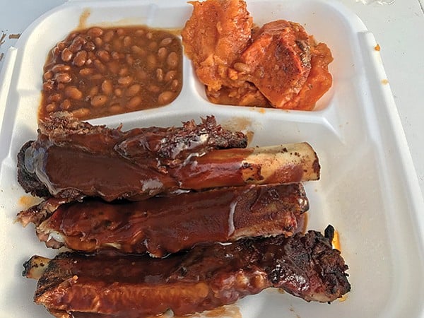 What $6.50 buys: three ribs, two sides. Here: baked beans and candied yams