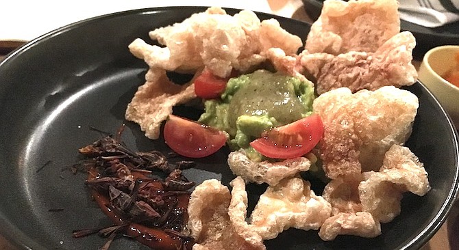 Tahona's guacamole is served with pork rinds, tomatoes, onions, and deep-fried crickets.