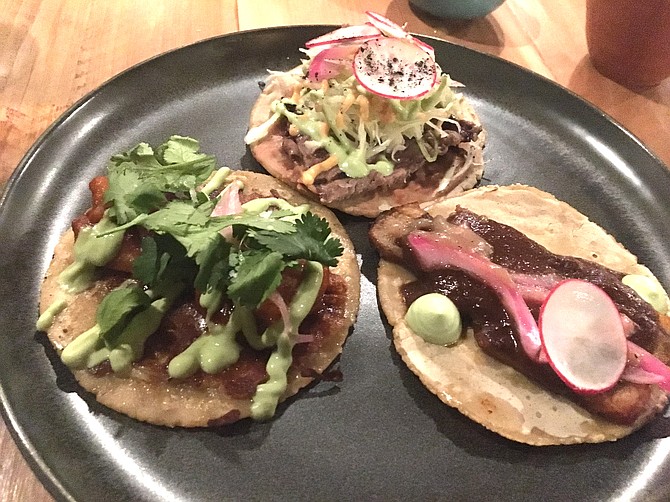 The taco menu includes clockwise from top, the carne asada with New York steak, the pork belly negro and the camarones a la diabla.