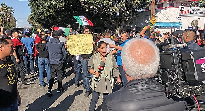 CNN reporter at Benito Juarez Field interviews an anti-migrant protester.