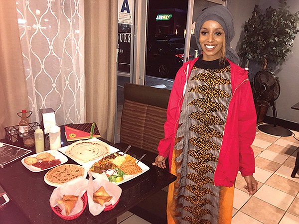 Farida’s daughter stands beside my Somali meal