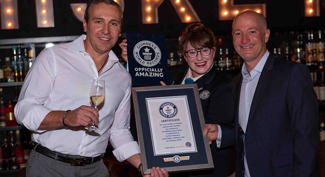 Whiskey House owners Alex Minaev and Ryan King celebrate as a Guinness judge awards a world record.