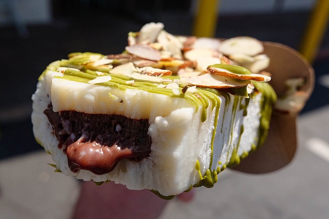A banana paleta with nutella inside, drizzled with white chocolate matcha and topped with slivered almonds
