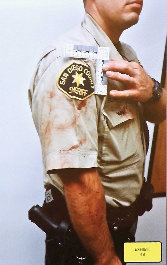 Deputy Elmone with dog blood on his uniform, after he carried Banjer away.
