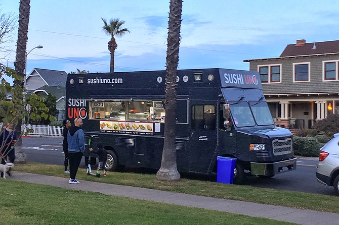 A sushi truck appears at a neighborhood park.
