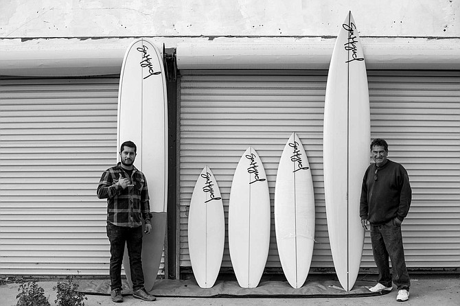 Chega and his son, Chega Jr. with a quiver of the surfboards.
