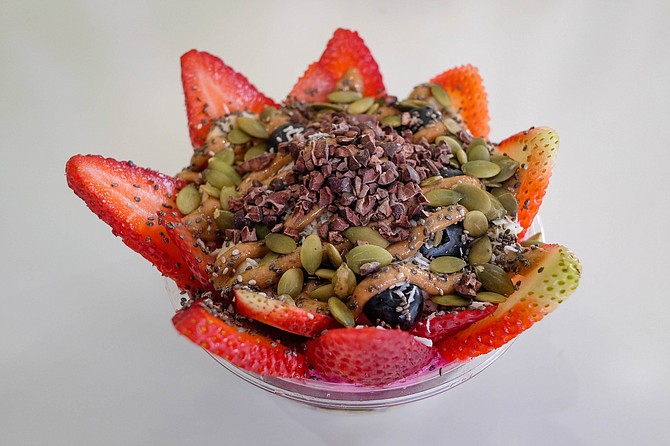 The signature roots bowl encircles a pile of superfoods with strawberries.