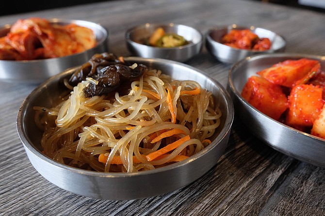 Sesame noodles, spicy daikon, and kimchi are part of Woomiok's banchan package.