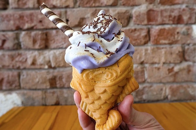 A taiyaki cone with a swirl of black sesame and ube soft serve
