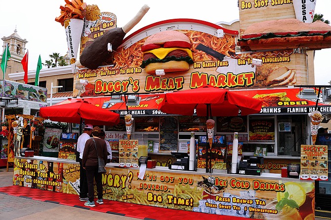 Like most fair vendors, Biggy's Meat Market uses loud photos and giant food models to attract attention