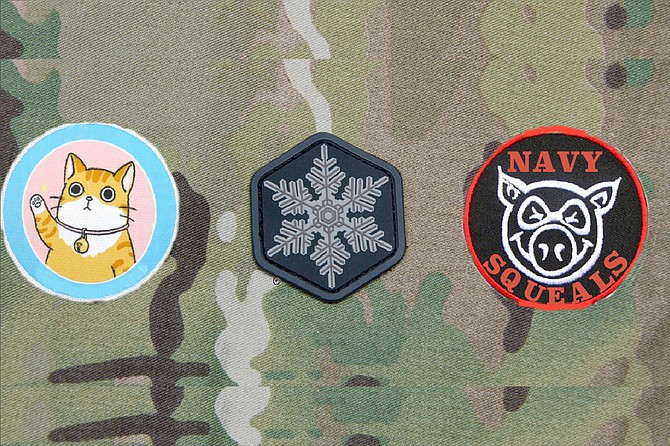 From left to right: The “Bunch of Pussies” patch, so called because, according to a letter provided to the Navy Times, Gallagher responded to criticism that it was extremely unnecessary to train troops by placing them in daytime live-fire situations by saying that his junior SEALs — several of whom testified against Gallagher — were “all a bunch of pussies” who needed the kind of engagement where “you need to focus on your field of fire or else you could take (a bullet) to the side of the head.” (The pussy in question notably wears a bell around its neck, much like the cat in the Aesop’s Fable, which serves to warn of its approach. This is taken as a reference to Gallagher’s decision to, as prosecutors put it, “spread rumors about his teammates to members of the SEAL community, describing them as cowards who were afraid to go out on missions,” even going so far as to “tell the new chain of command for teammates who had transferred.” Gallagher’s attorney did not deny the accusation, but preferred to call it “telling the truth.”) Second is the Snowflake patch, with its obvious designation of the young SEALs as members of the overly-emotional, easily offended, conflict-averse Generation Snowflake. (“This all started because these kiddies thought I was stealing from their care packages, and they get grumpy when they don’t get their afternoon milk and cookies,” Gallagher has been reported as saying. “So they ganged up and formed the military equivalent of an online mob and tried to cancel me. But the Navy isn’t Twitter, thank God.”) Finally, the Navy SQUEALs patch, wherein SQUEAL stands for Sissified Quisling Unable to Endure Actual Leadership. Because, as Gallagher’s attorneys put it, “Those little piggies tried to go wee, wee, wee all the way home, but the Big Bad Wolf was too smart for them.” A fourth patch, depicting a bulls-eye target and intended to be worn on the helmet, was considered but ultimately rejected. After all, said Gallagher, “We’re a brotherhood.”