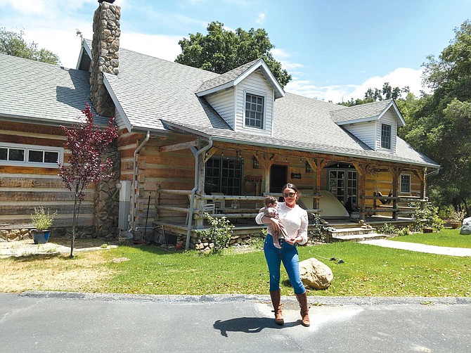 Angela Acosta stands in front of a Warner Springs home built in 1989 by Roger Craig, a World Series-winning baseball player