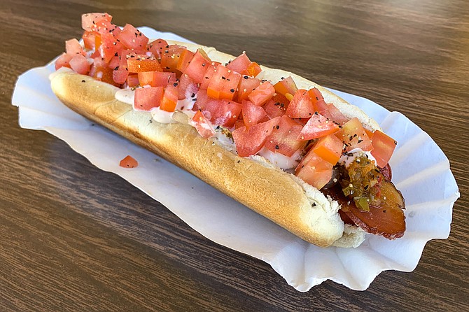 Specialty dog The 'O'. with jalapeño relish, Russian dressing, diced tomatoes, and a strip of bacon