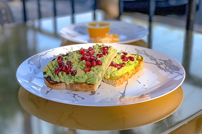 Pomegranate seeds find a place on avocado toast (ginger-turmeric wellness shot added for good measure).