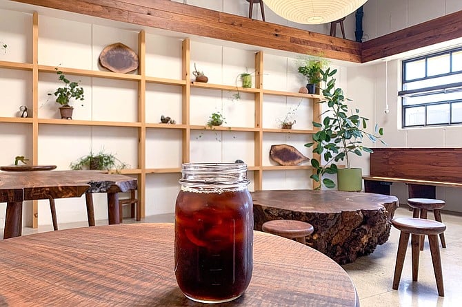 A jar of cold brew coffee in a lounge of specialty wood furnishings
