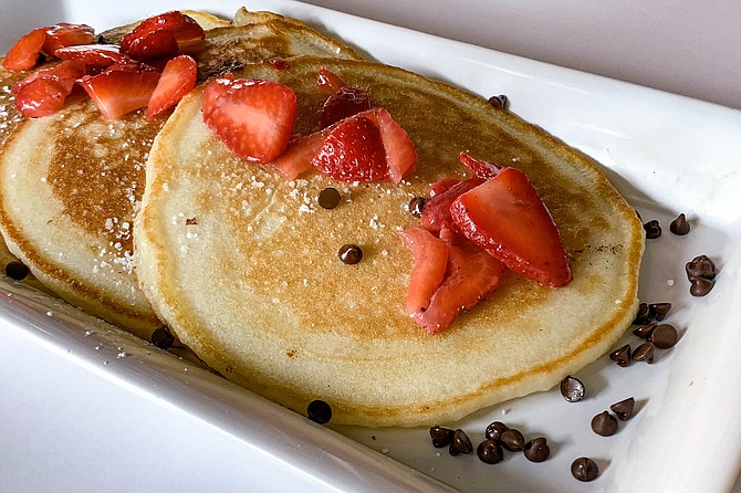 Basic B. pancakes topped with strawberries and chocolate chips