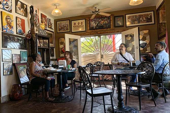 Patrons engage with the owners in one of the art- and music-infused dining rooms at Bowlegged BBQ.