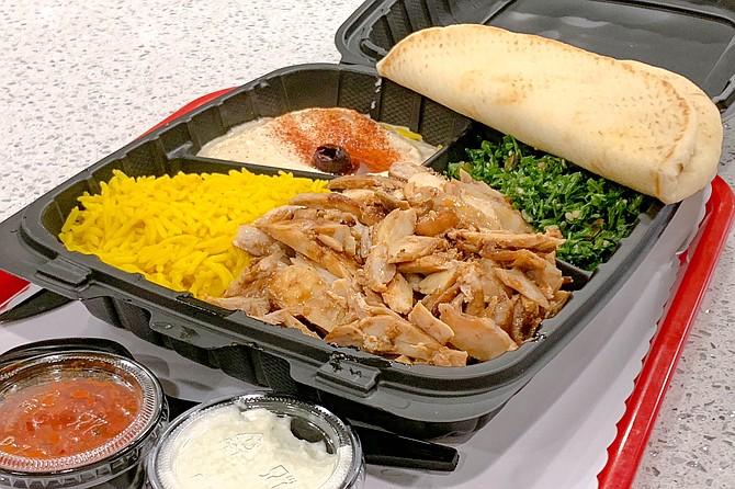 A chicken shawarma plate, served with house sauces and hummus