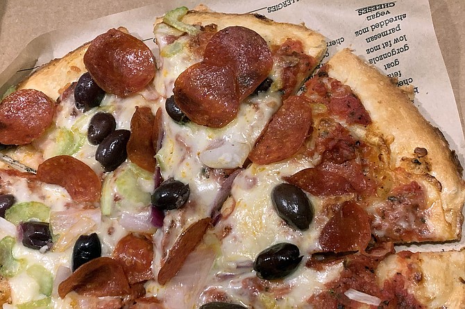 A pepperoni and kalamata olive pie with celery as a pizza topping