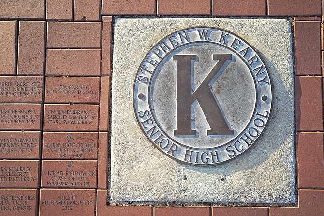 In the ground, beneath the Kearny Senior High School emblem, is a collection of bricks purchased by alumni and other supporters. “We’ve got some great names here,” Stephen Grooms says, pointing downward.