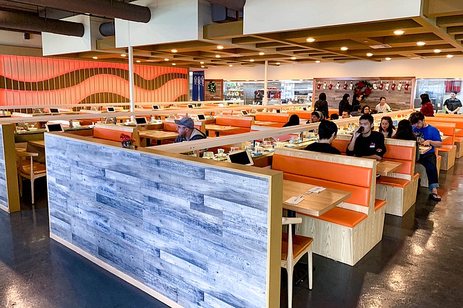 Orange booths connected to a glassed in kitchen by conveyor belts and monorails
