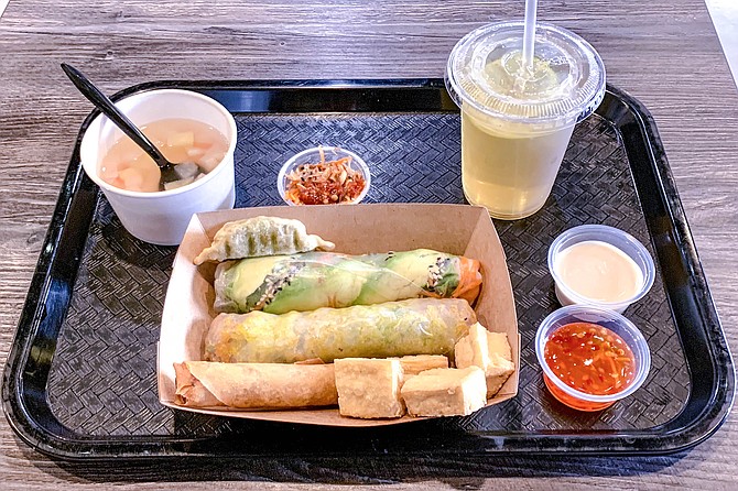 The vegan combo #4: egg roll, crispy tofu, dumpling, soup, tea, vegan crepes roll, and spring roll with avocado, pickled carrot, and sesame seeds