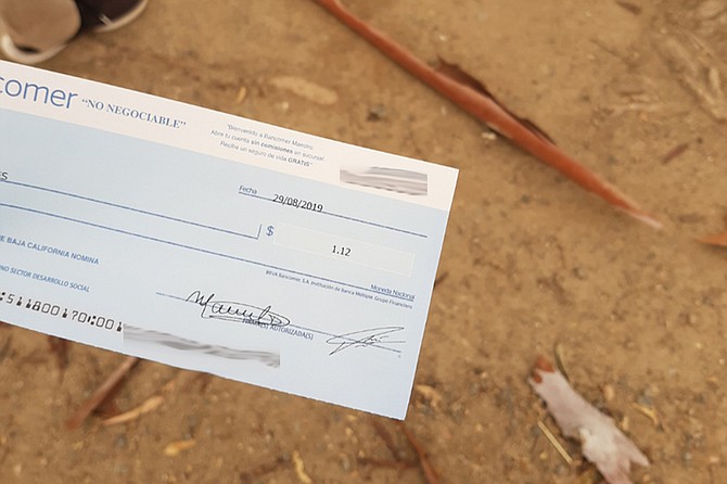 Alexis holds his check for 1.12 pesos. “For teachers who were owed 80,000 pesos, these checks were mockeries.”